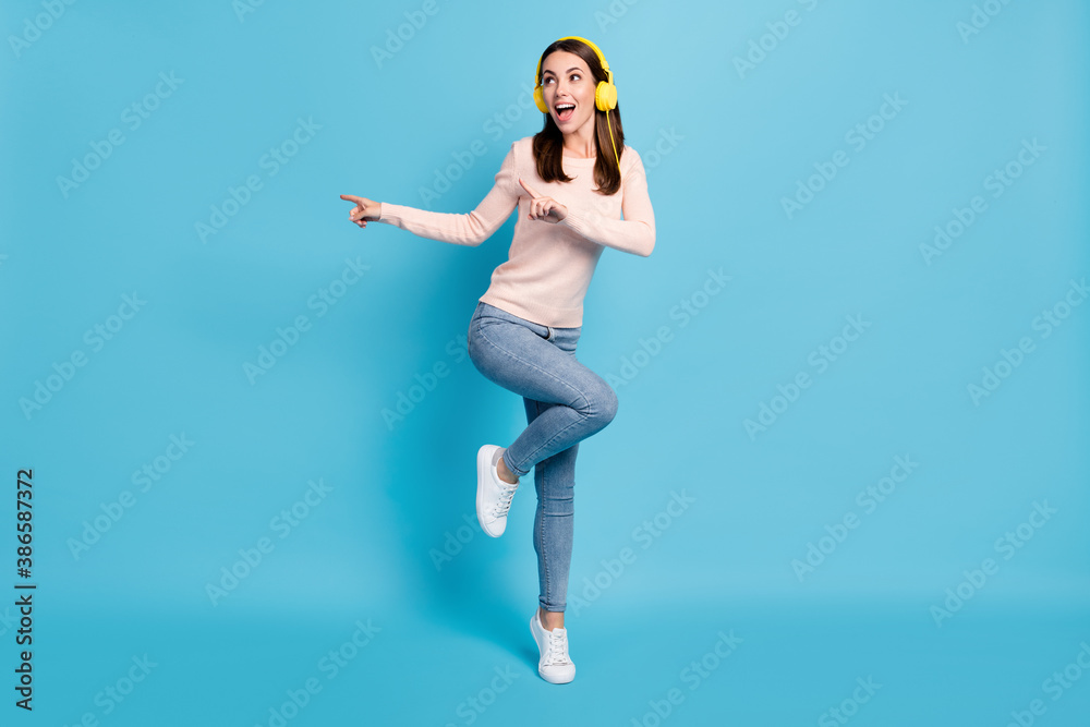 Full length body size view of her she nice attractive pretty cheerful cheery glad funky girl fan jumping listening hit dancing having fun isolated over bright vivid shine vibrant blue color background