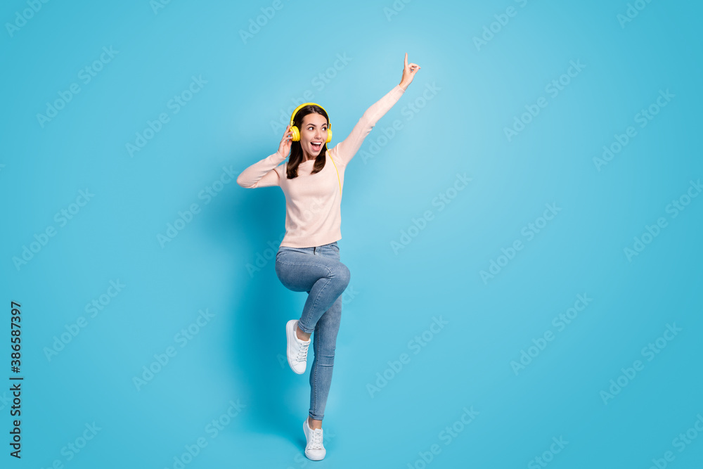 Full length body size view of her she nice attractive pretty cheerful cheery girl fan jumping listening hit bass dancing isolated over bright vivid shine vibrant blue color background