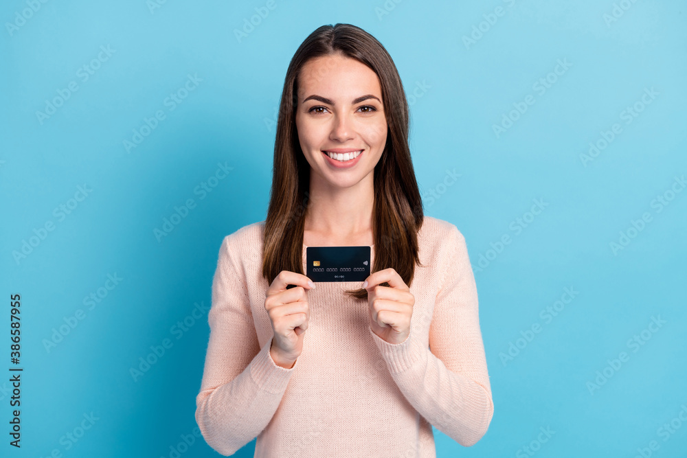 Close-up portrait of her she nice attractive pretty glad cheerful cheery brown-haired girl holding in hands bank card customer isolated on bright vivid shine vibrant blue color background Close-up portrait of her she nice attractive pretty glad cheerful cheery brown-haired girl holding in hands bank card customer isolated on bright vivid shine vibrant blue color background