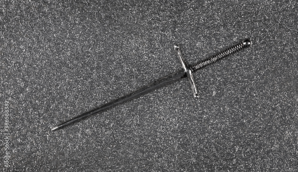 medieval sword isolated on gray metal background medieval sword isolated on gray metal background