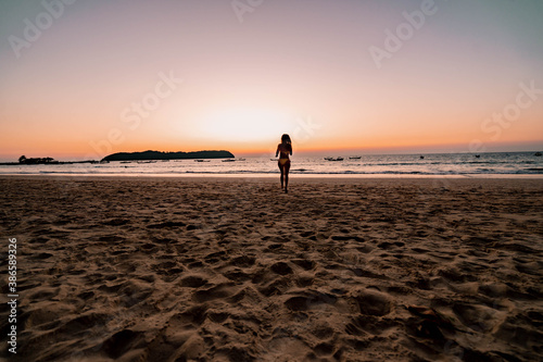 girl running on the beach at sunset