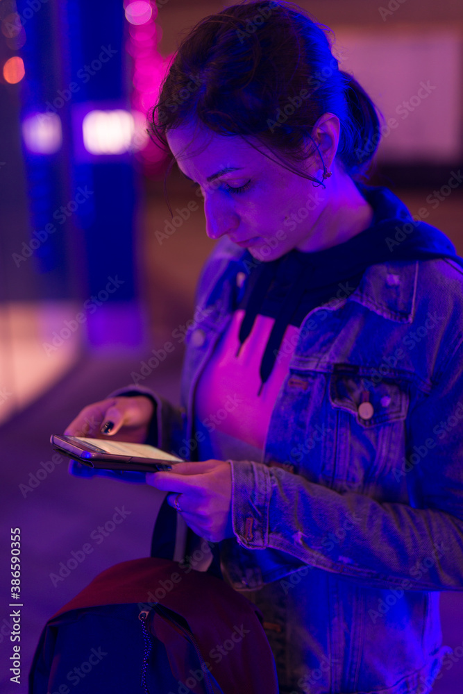 Woman holds a smartphone in her hand and looks at the screen