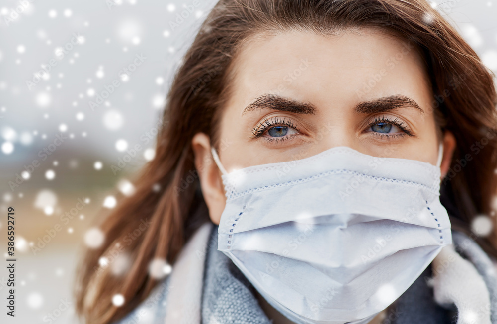 health, safety and pandemic concept - close up of young woman wearing protective medical mask outdoors in winter over snow health, safety and pandemic concept - close up of young woman wearing protective medical mask outdoors in winter over snow