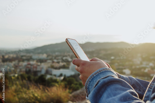 young lady using cell phone on the countryside. Rural internet connectivity concept. 