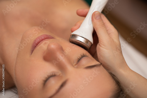 Close-up Of Woman Getting Facial Hydro Microdermabrasion Peeling Treatment At Cosmetic Beauty Spa Clinic. Face Skin Care. Hydra Vacuum Cleaner. Exfoliation, Rejuvenation And Hydratation. Cosmetology.