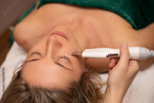 Close-up Of Woman Getting Facial Hydro Microdermabrasion Peeling Treatment At Cosmetic Beauty Spa Clinic. Face Skin Care. Hydra Vacuum Cleaner. Exfoliation, Rejuvenation And Hydratation. Cosmetology.