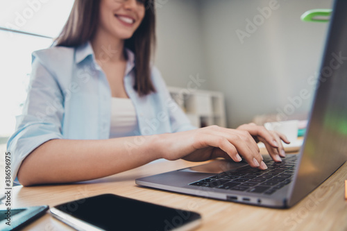 Cropped photo of pretty worker girl sit desk hands keyboard laptop wear shirt in home office indoors