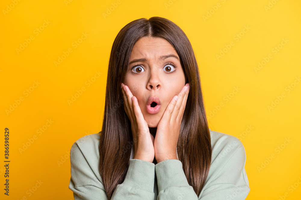 Photo of shocked impressed child girl dressed casual green outfit arms cheeks big eyes isolated yellow color background Photo of shocked impressed child girl dressed casual green outfit arms cheeks big eyes isolated yellow color background