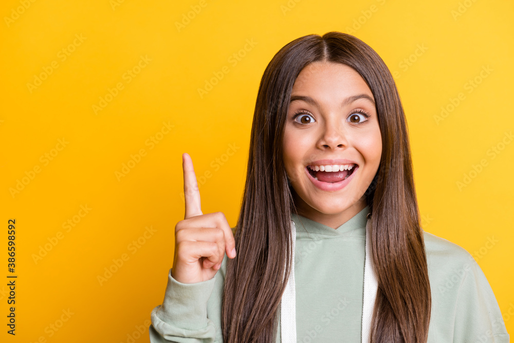 Photo of smart clever school girl wear casual grey outfit pointing empty space isolated yellow color background Photo of smart clever school girl wear casual grey outfit pointing empty space isolated yellow color background