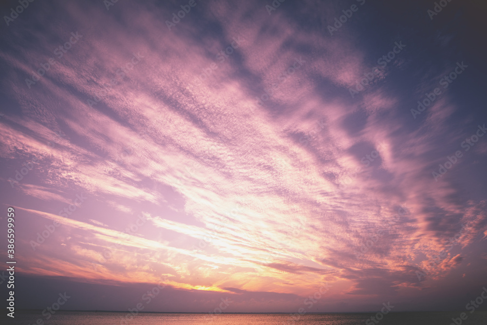 Sunset over the sea. Colorful cloudy sky at sunset. Gradient color. Sky texture. Abstract nature background