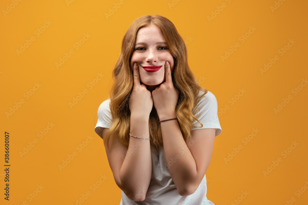Young woman pretends to smile, stretches her mouth into a smile and forcing himself cheerful. Fake smile concept Young woman pretends to smile, stretches her mouth into a smile and forcing himself cheerful. Fake smile concept