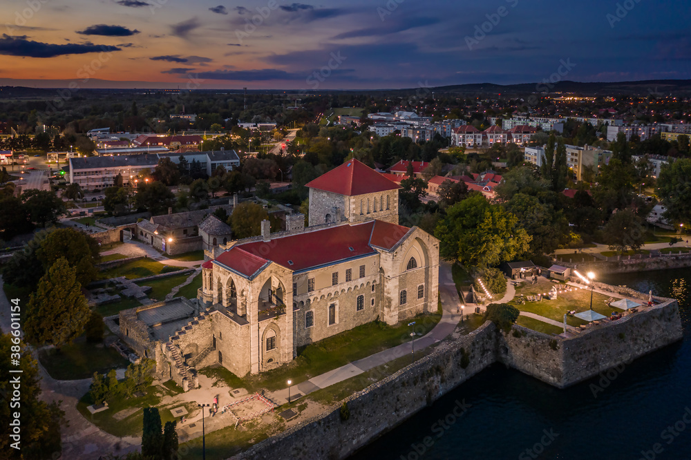 Tata, Hungary - Aerial view of the beautiful illuminated Castle of Tata by the Old Lake (Öreg-to) at dusk with colorful clouds and sky on a summer evening
