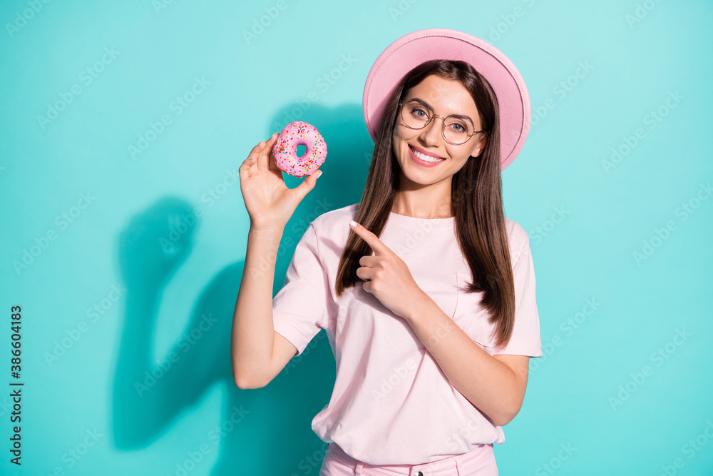 Portrait of her she nice attractive cheerful cheery brown-haired girl holding in hand showing pink fresh tasty donut isolated bright vivid shine vibrant green turquoise color background Portrait of her she nice attractive cheerful cheery brown-haired girl holding in hand showing pink fresh tasty donut isolated bright vivid shine vibrant green turquoise color background