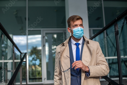 Businessman leaves the office with a face mask protect from Coronavirus. photo