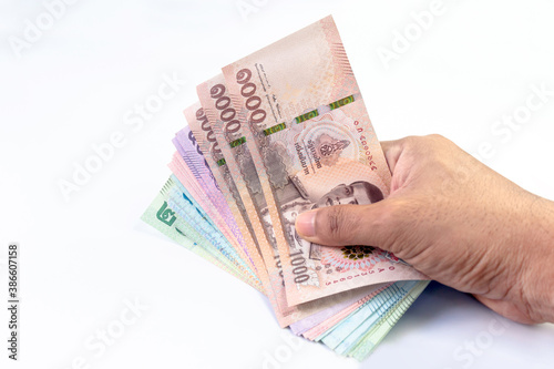 money banknote thai baht in hand close-up, (savings, shopping, pay, borrow concept), hand holding paper money