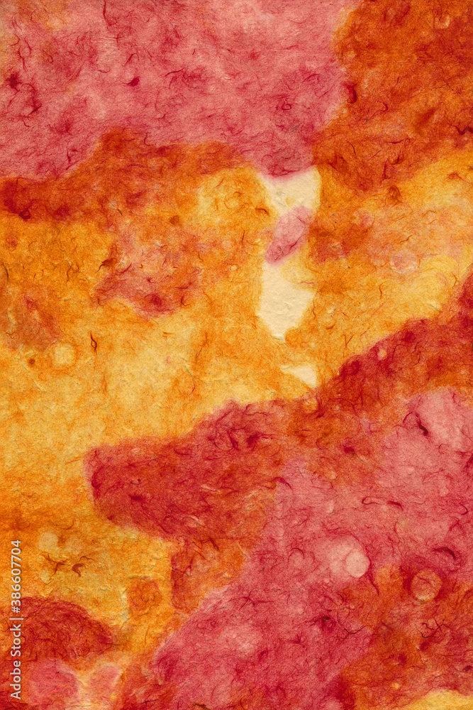Bright red and orange background of crumpled paper or rough plaster for design or text. Surface texture. Vertical shot. Close-up.