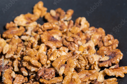 Close up of walnuts in dark grey cast iron pan for roasting spices photo