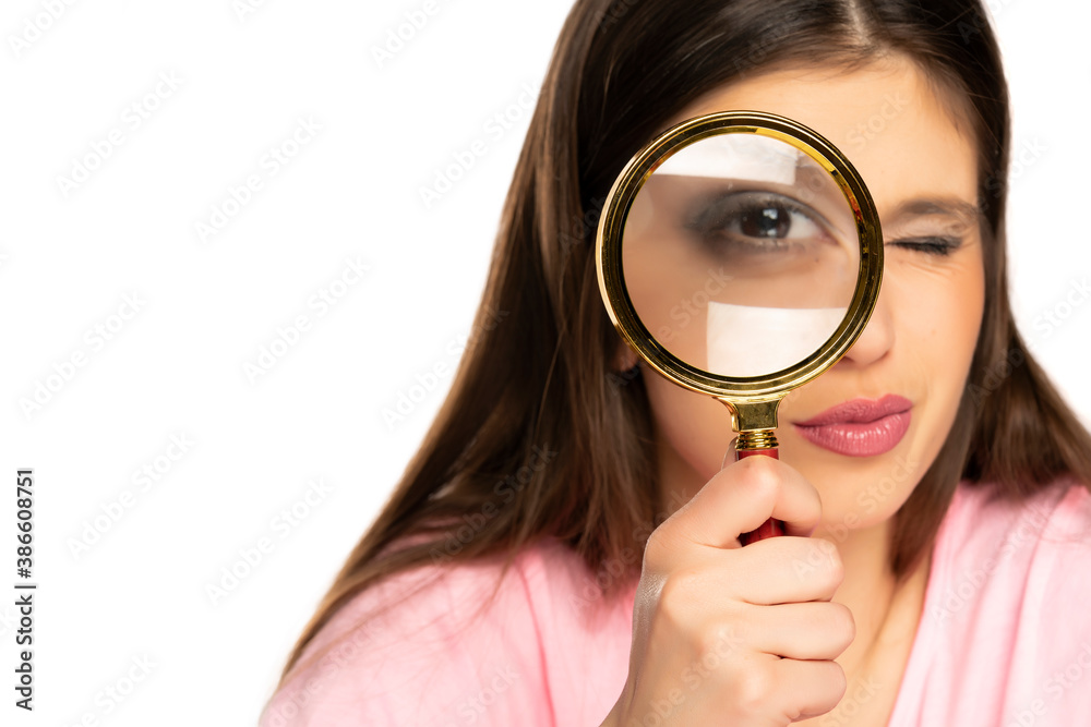 a young woman stares through a magnifying glass a young woman stares through a magnifying glass