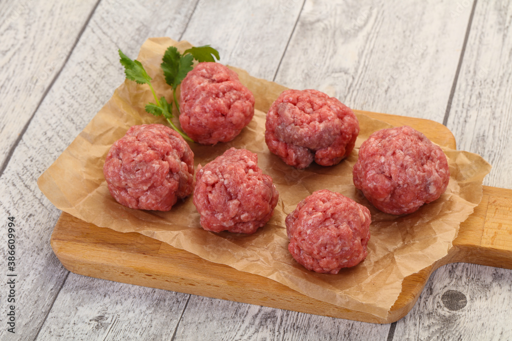 Raw meatball over wooden background Raw meatball over wooden background