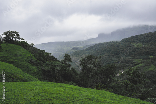 Landscape filled with Trees and a Valley in the background during monsoons