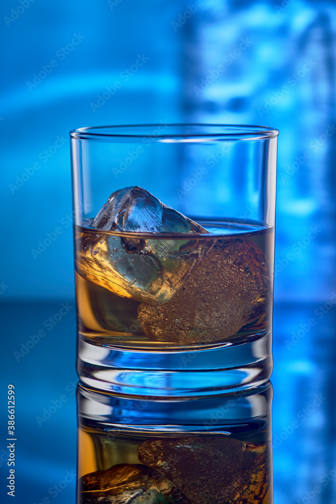 A glass of whiskey with ice. A glass of whiskey with ice.