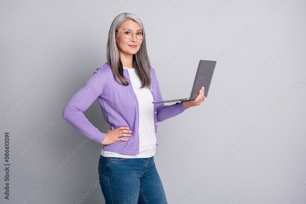 Photo portrait of confident attractive business woman holding keeping laptop posing in casual clothes isolated on grey color background Photo portrait of confident attractive business woman holding keeping laptop posing in casual clothes isolated on grey color background