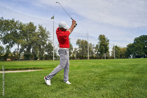 Diligent professional golfer training on the course