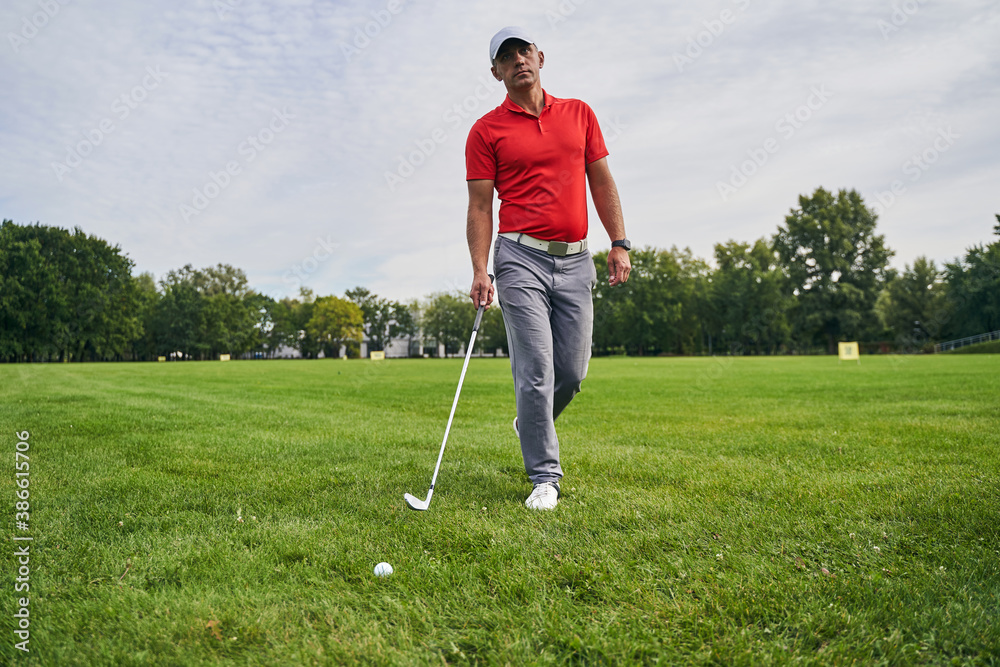 Fototapeta premium Sporty man carrying a wedge golf club