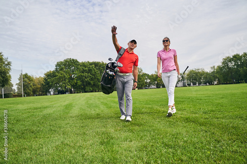 Female golfer and her personal trainer staring into the distance