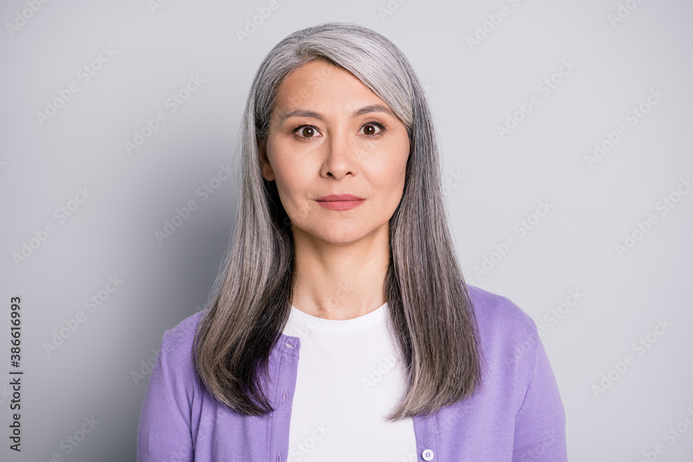 Portrait photo of an calm old lady with long white hair wearing purple ...