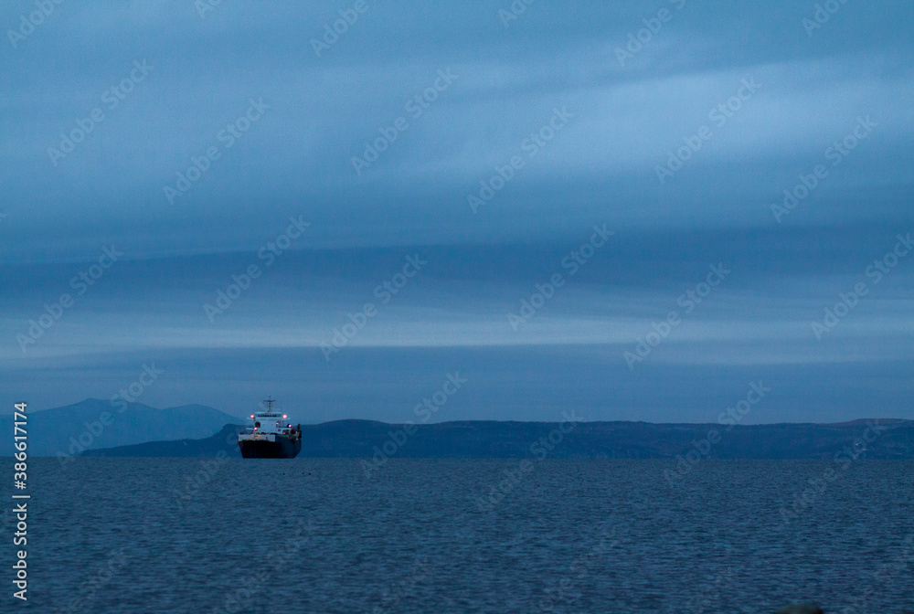 A boat in the middle of the sea in the blue of the dusk