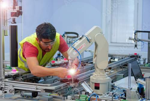 Wallpaper Mural Close-up of Service Engineer ( Mechanic ) with safety glasses, repairing robot arm in a technology laboratory. Industry 4.0 concept of smart factory prototype. Torontodigital.ca