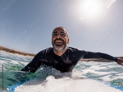 Happy caucasian south european spanish adult surfer having fun in the water 