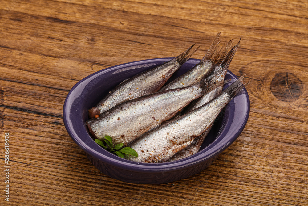 Anchovies in the bowl served basil leaves Anchovies in the bowl served basil leaves