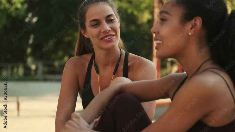 Happy young multinational women are talking sitting in the park Happy young multinational women are talking sitting in the park
