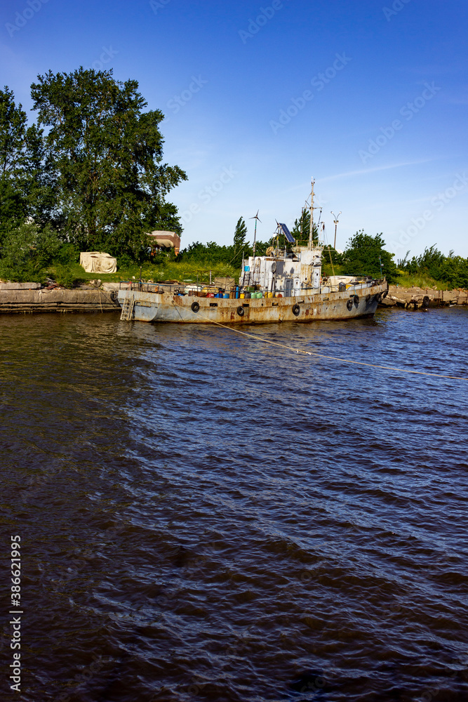 The city of Kronstadt. Russia. June 12, 2019. A rusty ship is moored in the port. The middle of the harbor. Urban landscape.