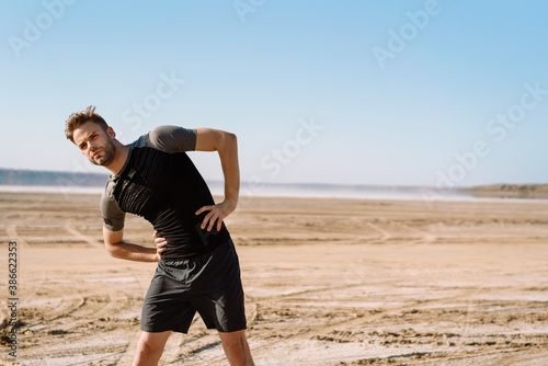 Motivated focused young sportsman exercising