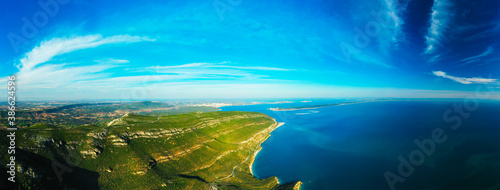 Aerial panoramic view of blue Atlantic ocean, green forest mountains, sandy beaches and beautiful blue sky. Galapinhos Beach and Serra da Arrabida, Portugal. photo