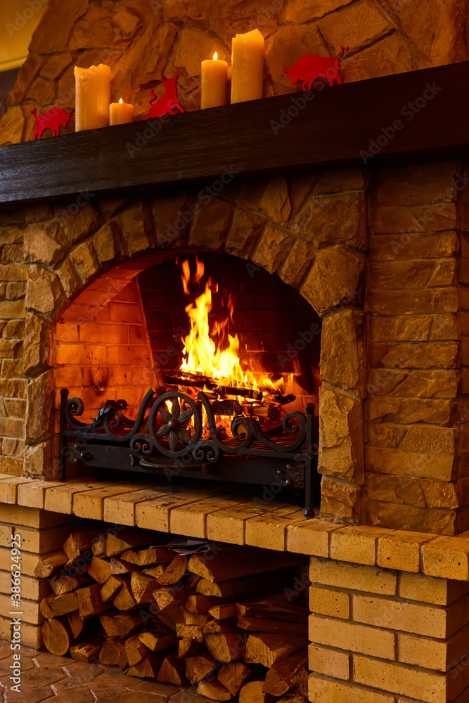 Warm cozy fireplace with real wood burning in it. Cozy winter concept. Christmas and travel background with space for your text. Warm cozy fireplace with real wood burning in it. Cozy winter concept. Christmas and travel background with space for your text.