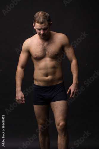 Handsome man in underwear on the black background. Muscular and athletic. Underwear man portrait. Male underwear model in studio 