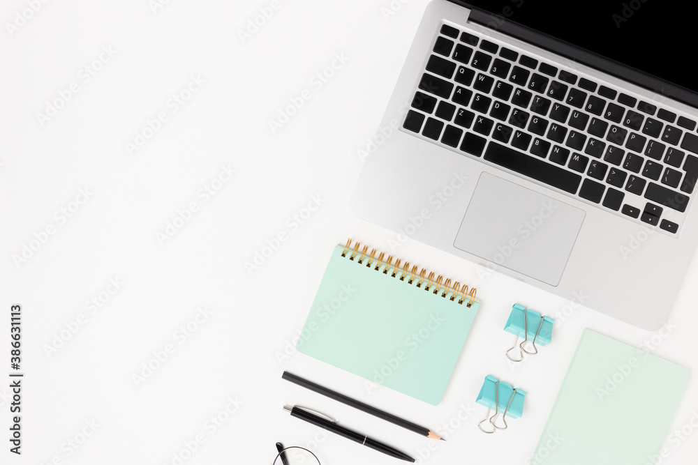 Workspace layout with laptop and office supplies. White table with copy space. Workspace layout with laptop and office supplies. White table with copy space.