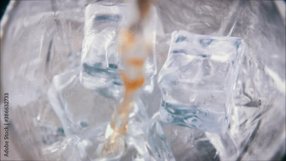 Slow Motion Macro Shot of Pouring Whiskey into Glass with Ice Slow Motion Macro Shot of Pouring Whiskey into Glass with Ice