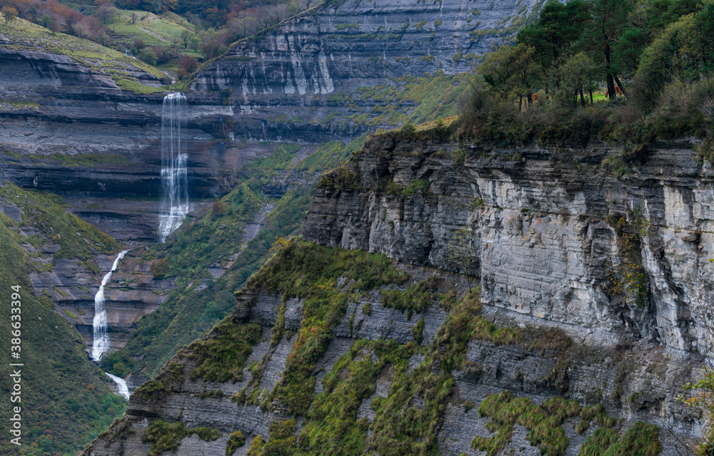 Naklejka premium Autumn landscape at the San Miguel waterfall in the Angulo Valley of the Mena Valley in the Merindades of the province of Burgos. Castilla y Leon, Spain, Europe