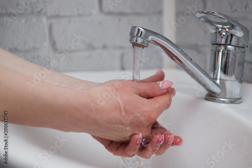 washing hands at bathroom sink man hand hygiene for corona virus pandemic precaution by washing hands frequently for 30 seconds. Prevent coronavirus, hygiene to stop the spread of coronavirus.