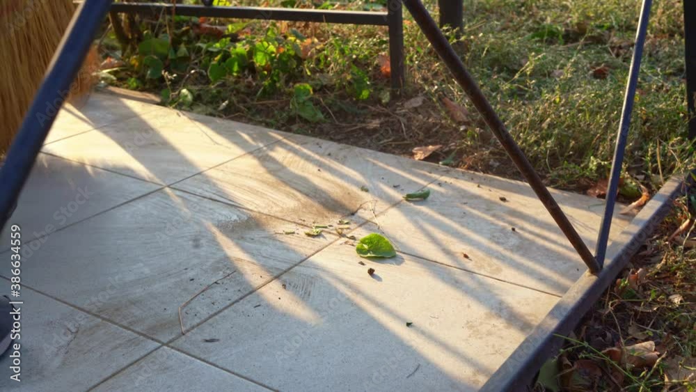 Cleaning cemetery. woman sweeps broom grey slabs and monument grave with rag. Cleaning cemetery. woman sweeps broom grey slabs and monument grave with rag.