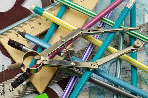 A variety of stationery in a chaotic mess are spread out on the table, background
