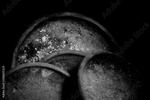 Old dirty and useless clay pans in black and white. Clay pans in a low key. photo