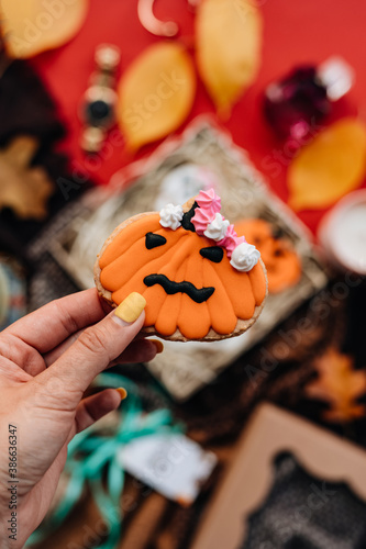 Halloween concept with cookies in hands on colorful background © Ann