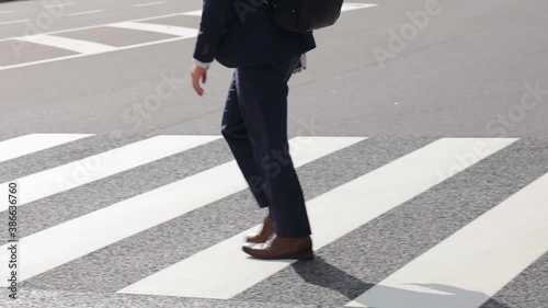 横断方向を渡るビジネスマンの足元のスローモーション