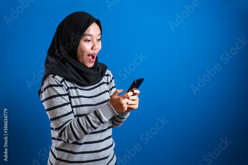 Young Muslim Woman Shocked Expression, Looking at Her Phone